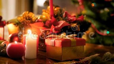 特写4k镜头的礼品盒，燃烧蜡烛和传统的圣诞花环在桌子上。 冬天的完<strong>美背</strong>景